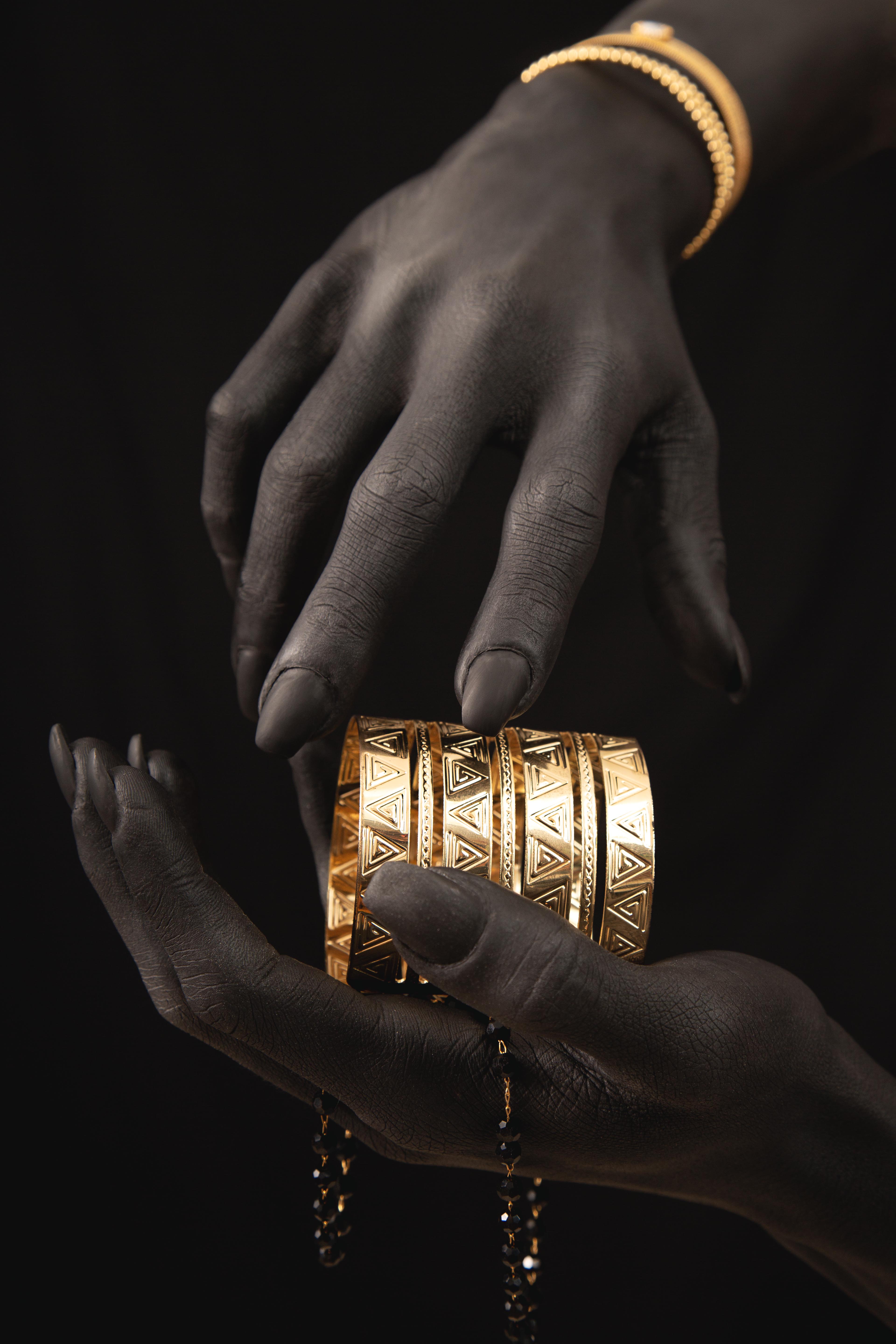 Gros bracelets en or sculpté tenus