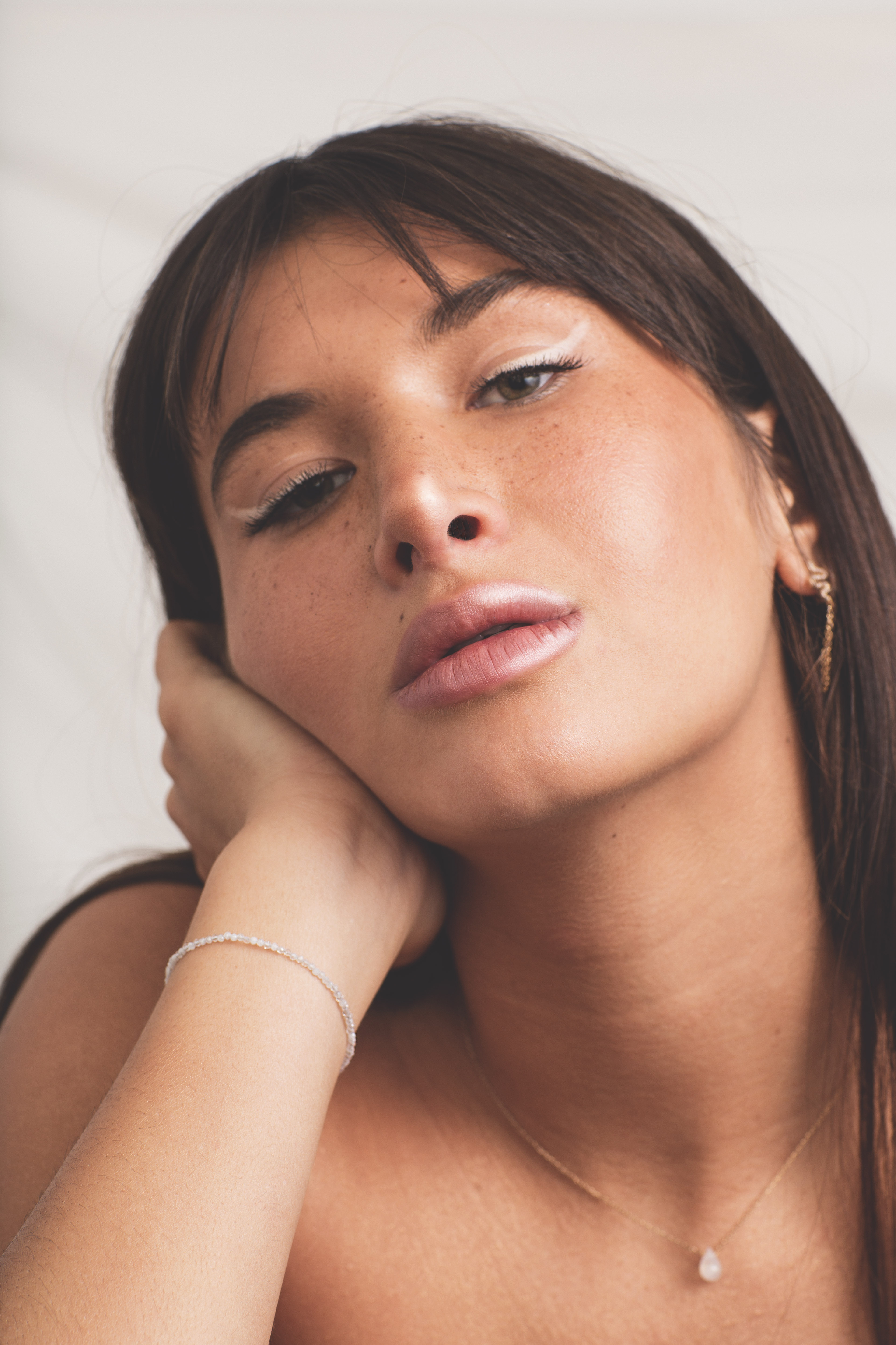 Gros plan sur le visage d'une femme portant des boucles d’oreilles dorées