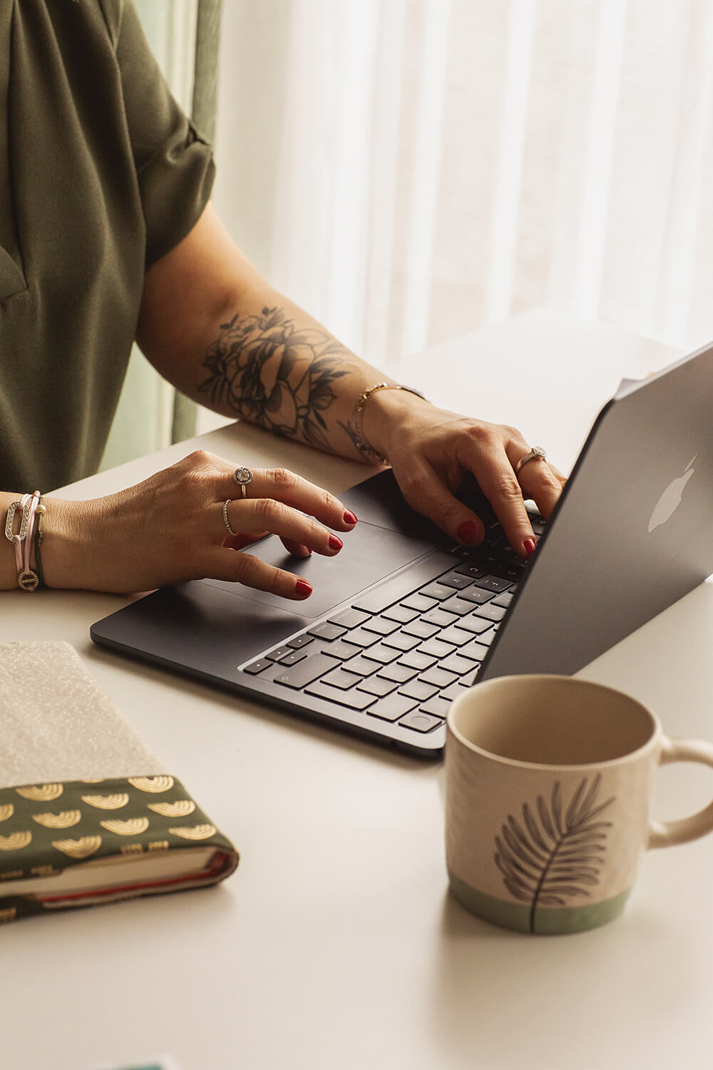 Femme assise sur son bureau travaillant sur son ordinateur portable