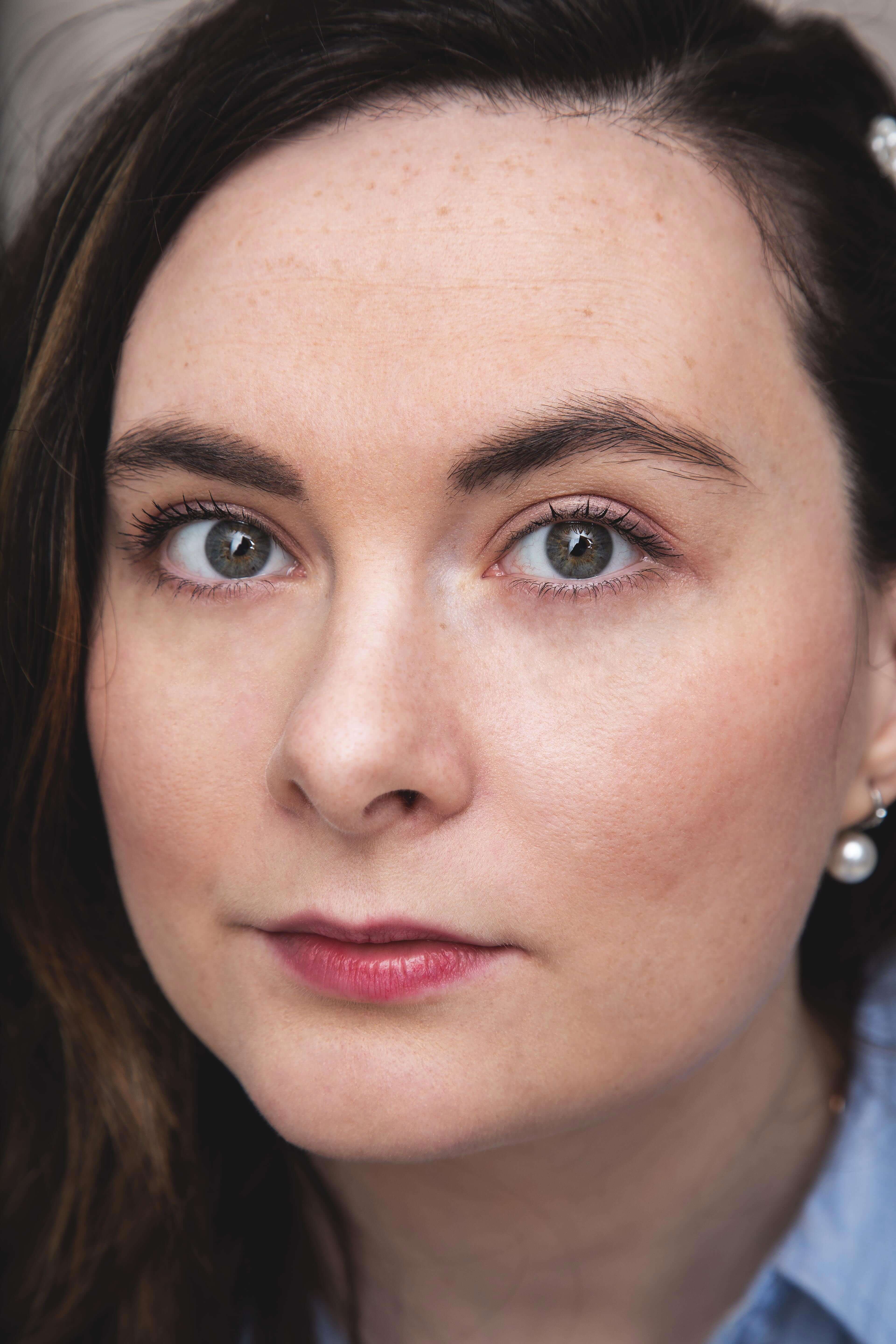 Portrait rapproché d’une femme aux yeux clairs, maquillage naturel