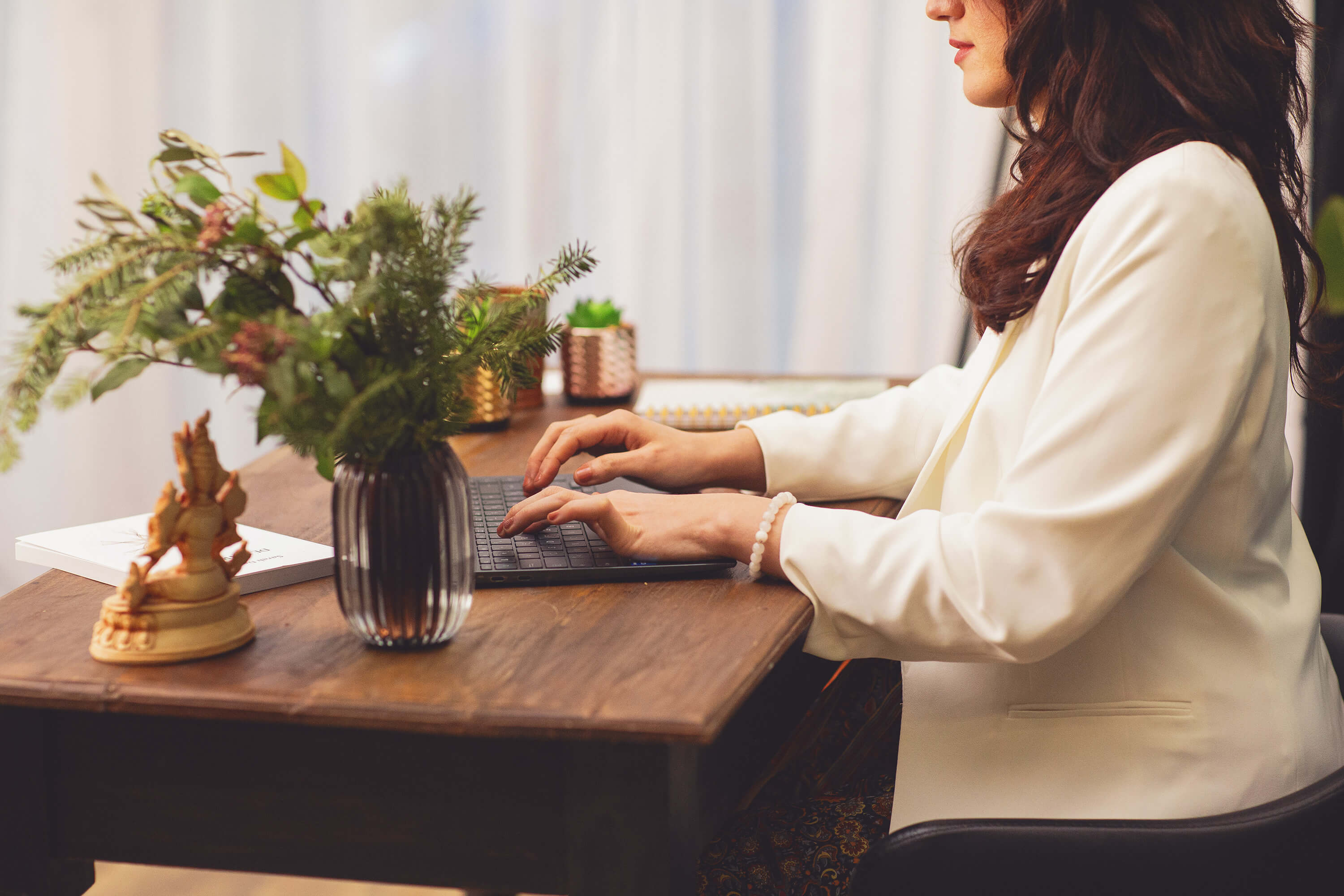 Thérapeute assise sur son bureau travaillant sur son ordinateur