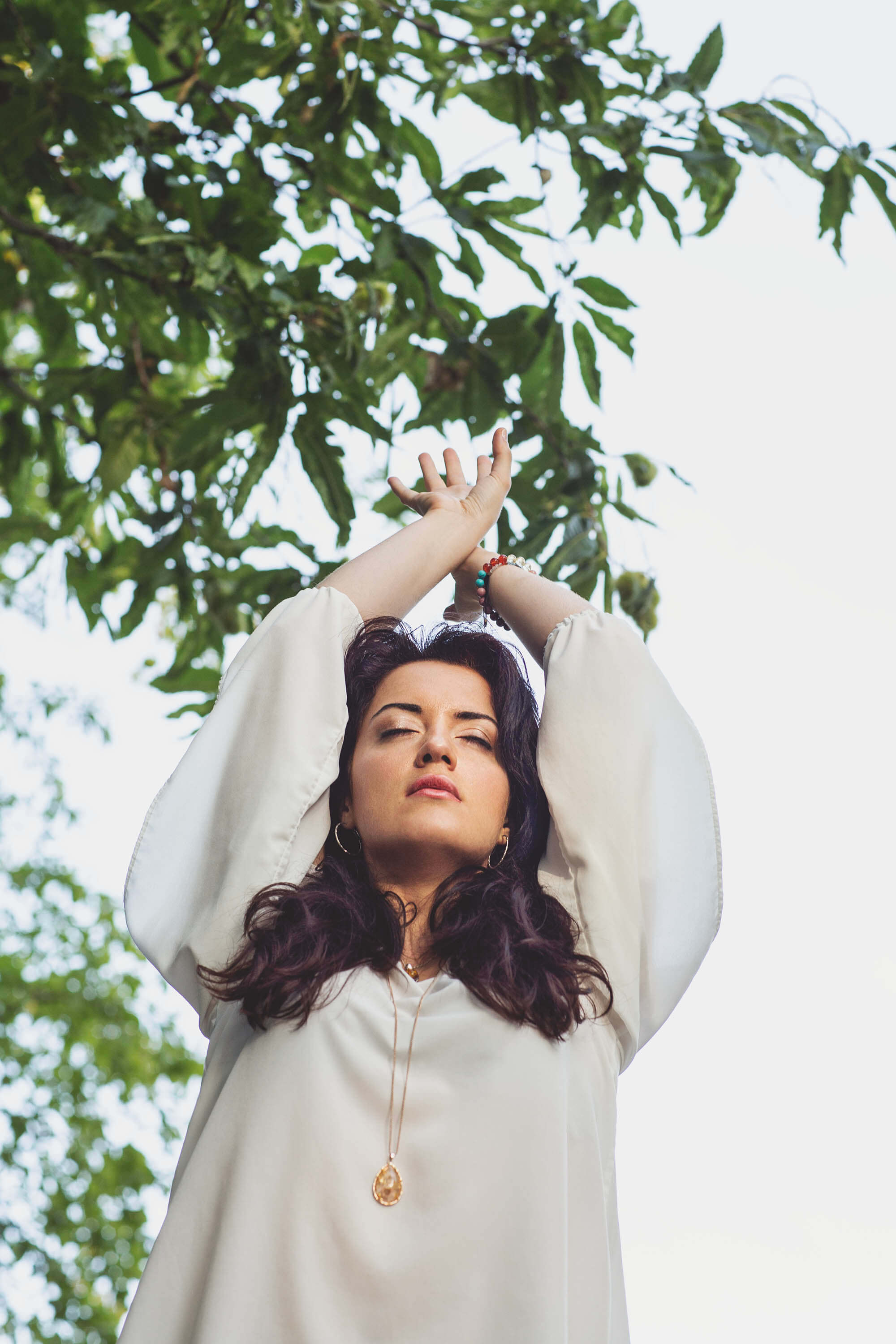 Femme en pleine nature, les bras levés, ambiance de reconnexion et de bien-être
