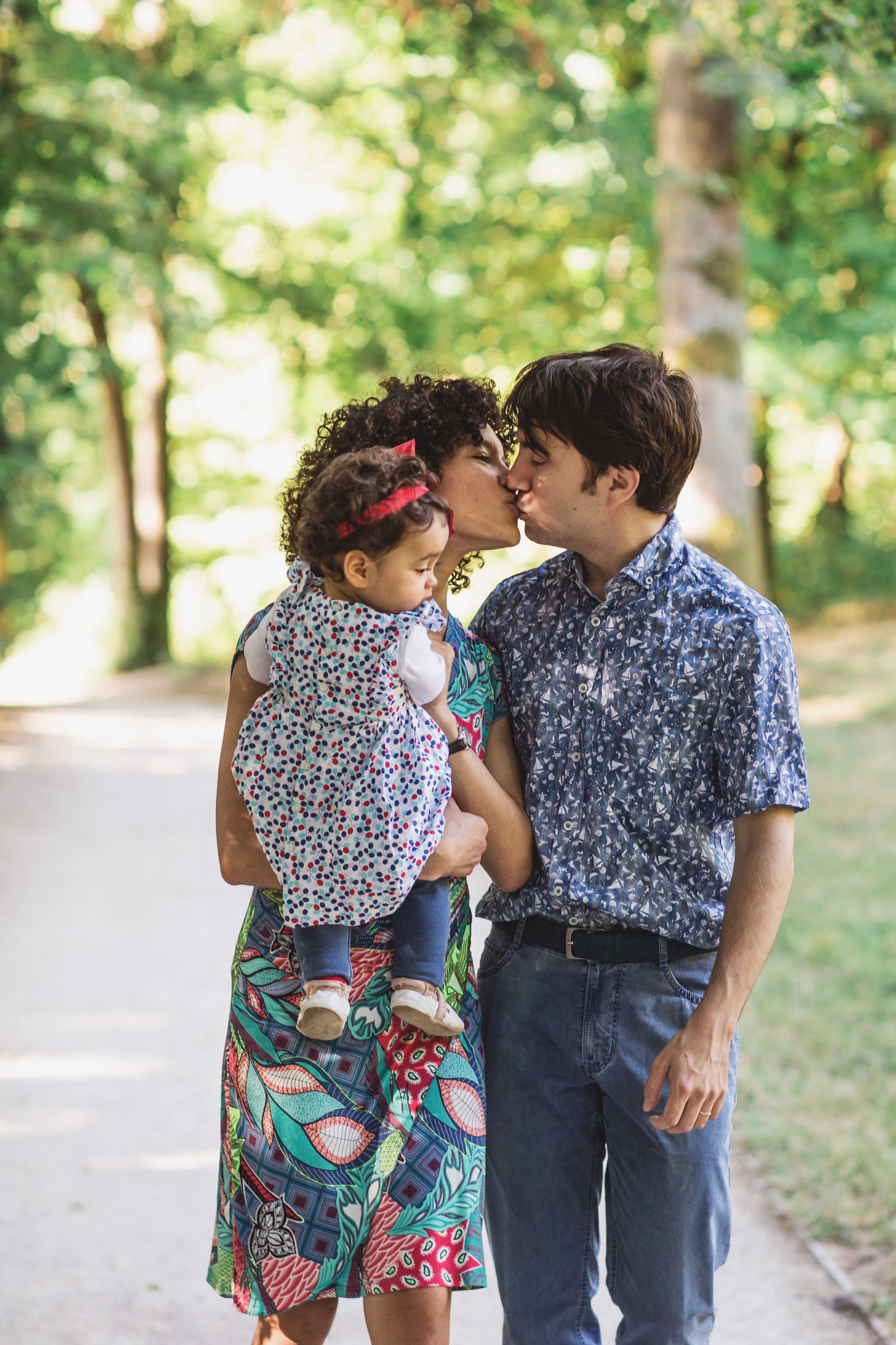 Famille avec un enfant dans les bras des parents dans un parc