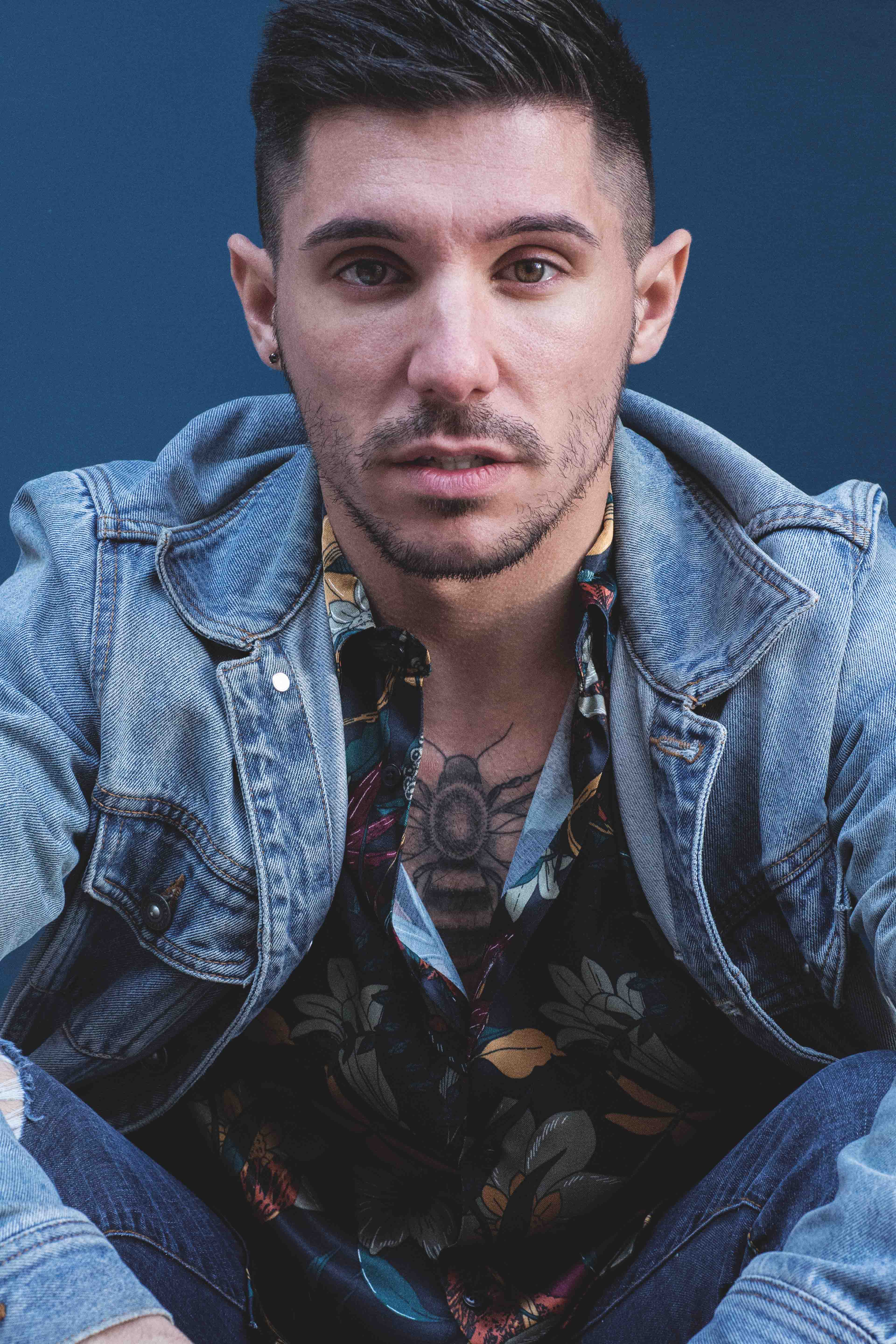 Portrait d’un homme tatoué en chemise et veste en jean