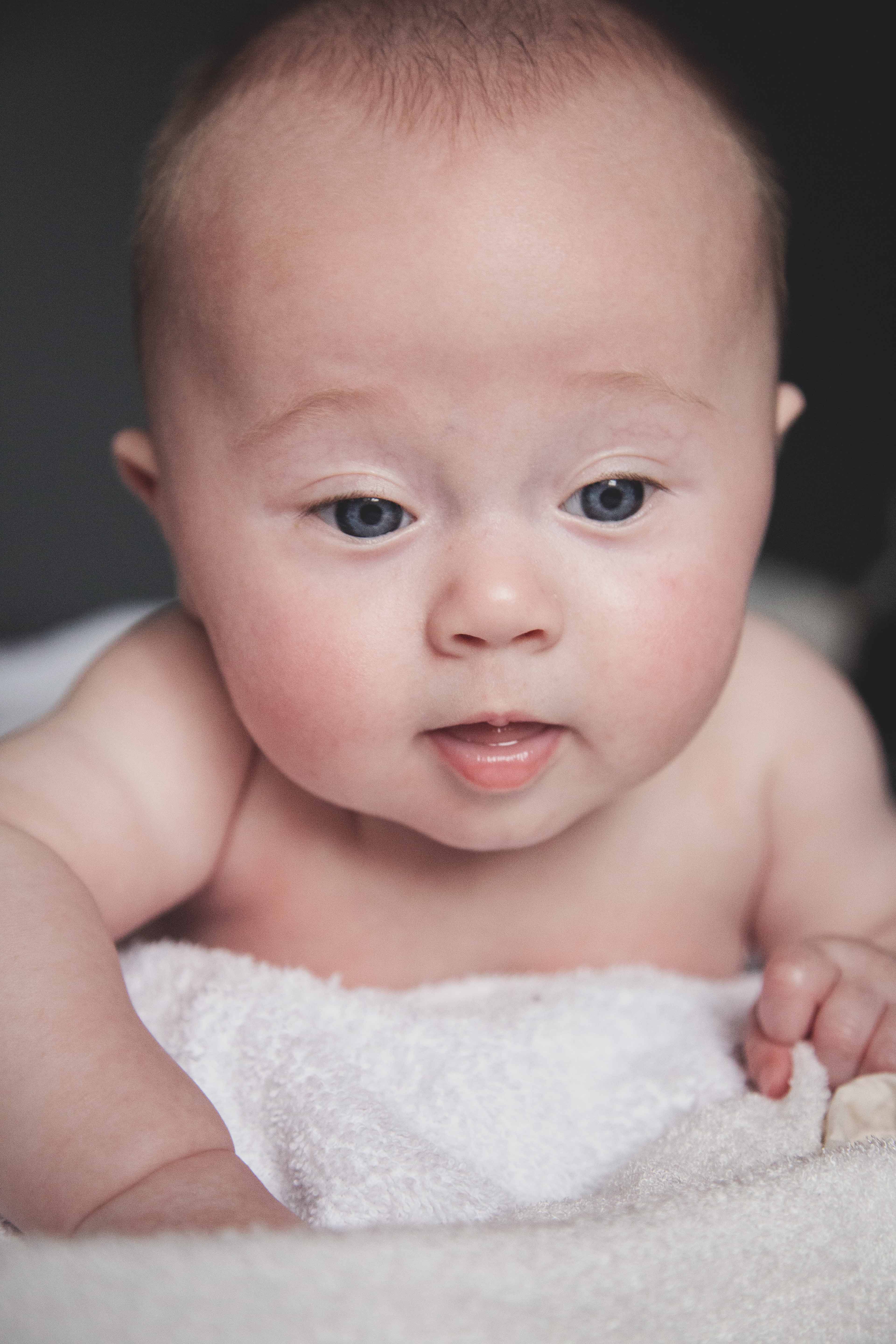 bébé allongé sur une serviette blanche