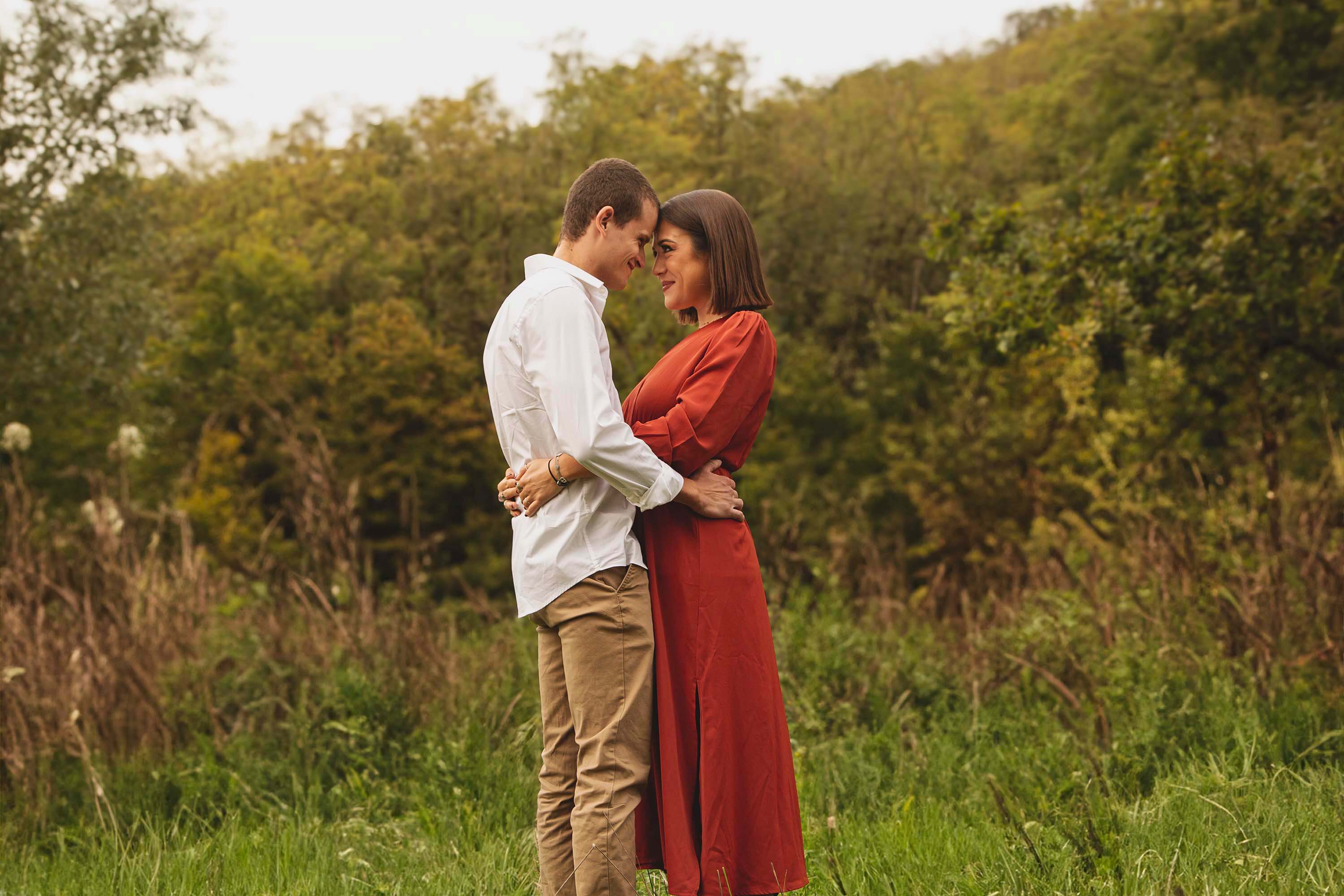 Couple amoureux se tenant par la taille dans un champ