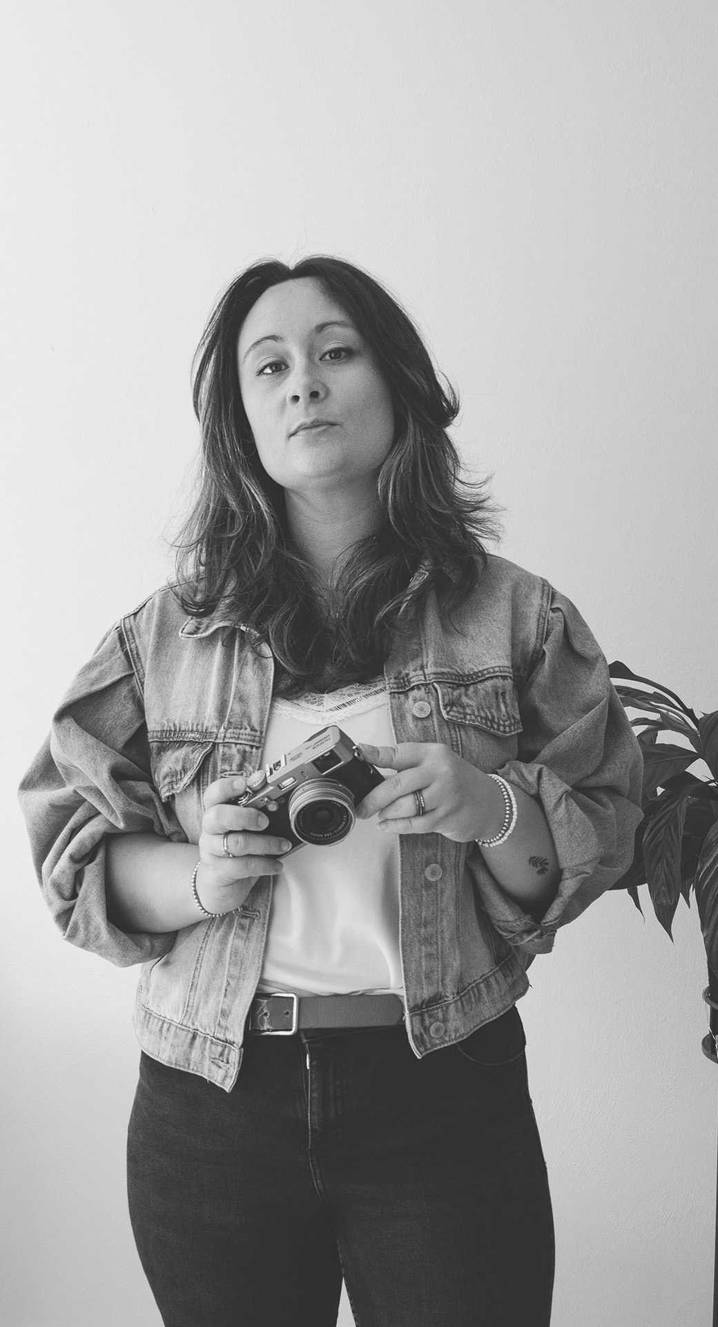 Une photographe professionnelle debout tenant son appareil photo dans la main